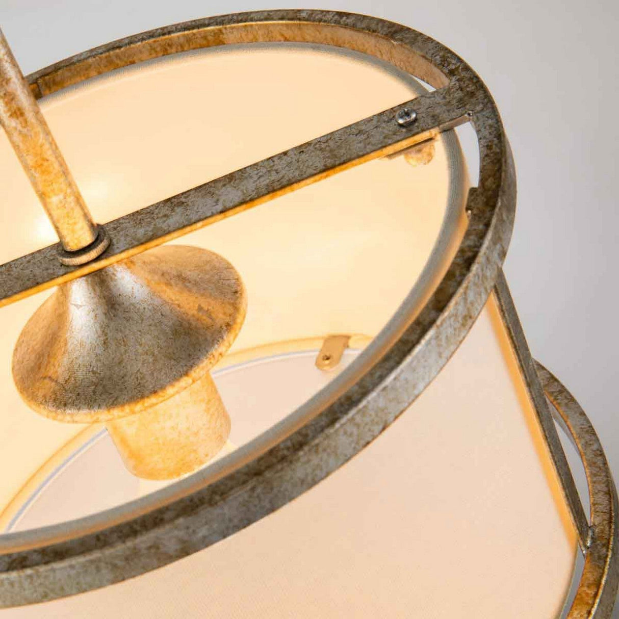 A close-up view highlights the Lemuria 1 Light Duo-Mount Mini Pendant/Semi-Flush, showcasing its gold metallic fixture and ivory shade that emits a warm glow. The design features textured metal and adjustable height rods, offering an industrial yet contemporary look.