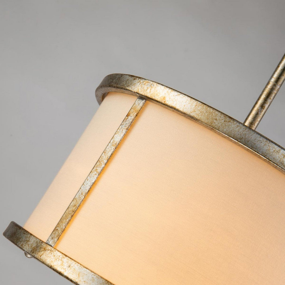 A close-up of the Lemuria 1 Light Duo-Mount Mini Pendant/Semi-Flush features an ivory shade with a metallic gold frame, adorned with a subtle Grecian key motif. The angled shade highlights its texture and rustic finish, complemented by adjustable height rods against a neutral gray background.