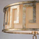 Close-up of a metallic circular lampshade showcasing a geometric pattern with rectangular cutouts. The Lemuria 3 Light Duo-Mount Large Pendant/Semi-Flush in gold with an ivory shade exudes elegance, revealing warm light through the beige inner lining and offering adjustable rods for versatile placement.