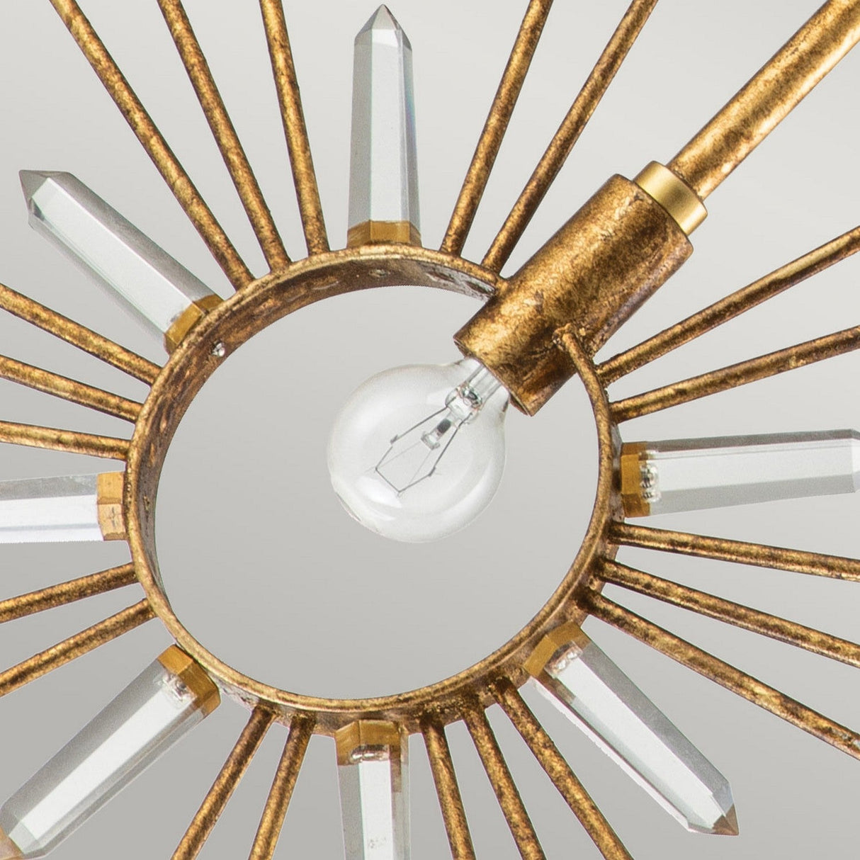 The Sun King 1 Light Pendant in Gold Leaf is an adjustable decorative pendant light with a starburst design, featuring a central circular bulb surrounded by radiating metal rods that hold crystal accents. Its metallic finish lends an elegant and modern appearance.