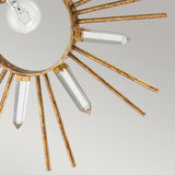 A close-up of the Sun King 1 Light Pendant - Gold Leaf reveals its adjustable pendant light with a starburst design, showcasing a golden sunburst and gold leaf finish. The clear crystal rods extend from the circular frame, encircling a visible light bulb against a neutral background.