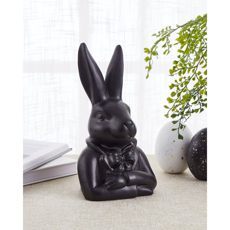 Gopeng Rabbit Ornament 23.2cm in Black, a sculpted figurine of a rabbit in a bow tie and jacket with folded arms, displayed on a table near a book and decorative eggs.