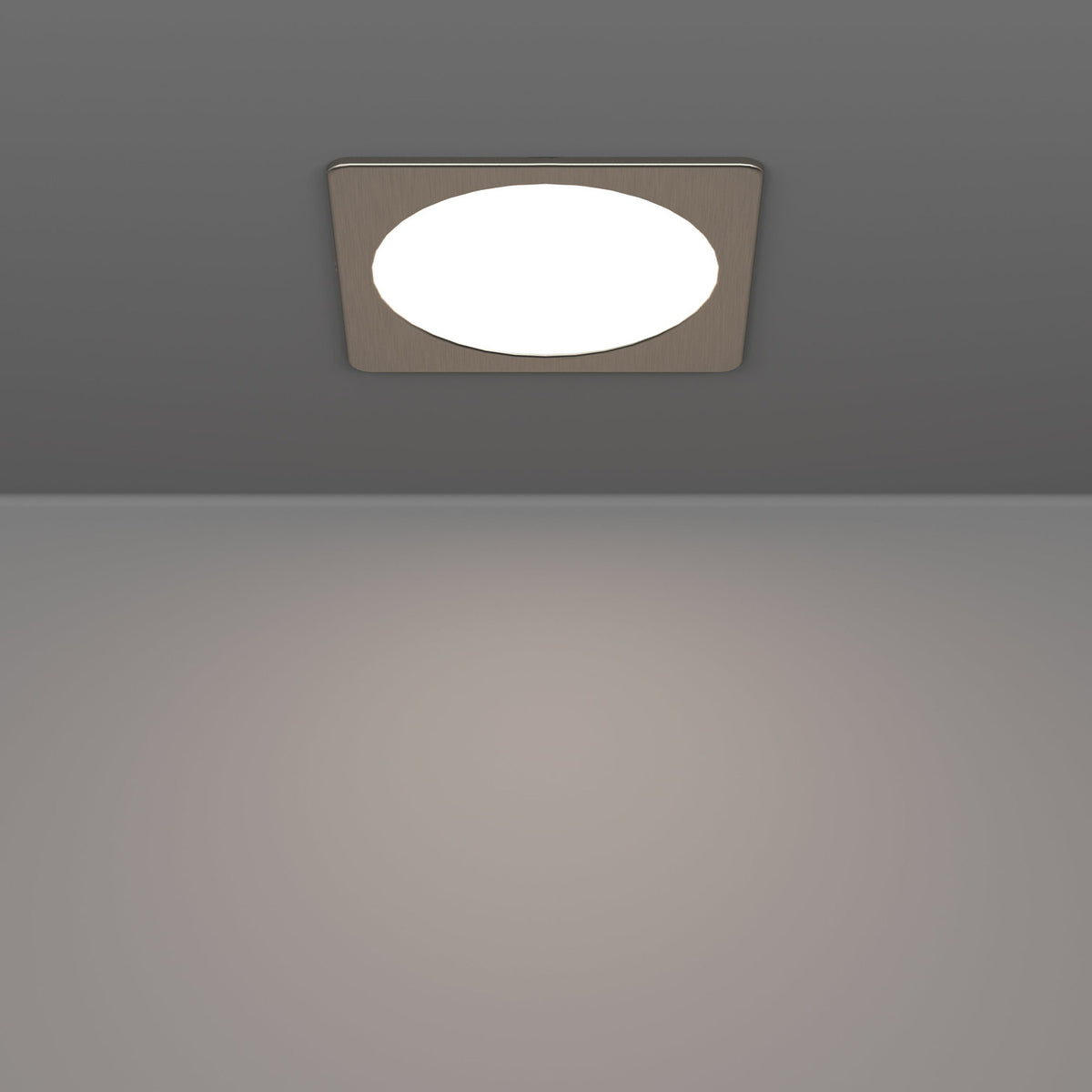 Gosmelle LED downlight recessed into a grey ceiling, showing a square satin nickel trim with a round white diffuser emitting warm light onto the surface below.