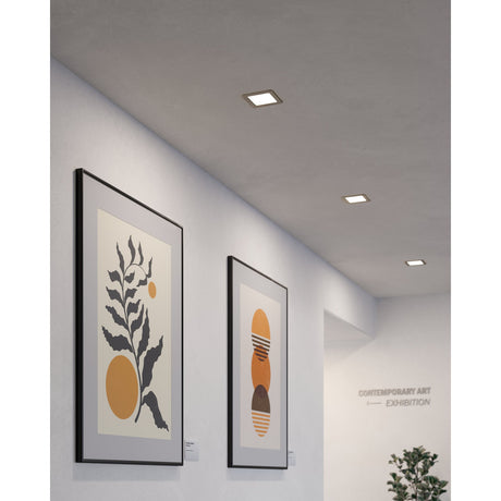 Gosmelle square LED recessed downlights with satin nickel frames, shown fitted in a gallery hallway ceiling above framed artwork.