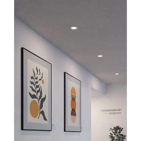 Gosmelle LED downlights, round white trim, recessed into a grey ceiling above framed artwork in a gallery-style hallway with cool white light.