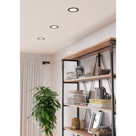 Gosmelle LED Downlight, 11.9cm round black-rimmed fixtures with white diffusers, recessed into a living room ceiling above a wooden shelving unit.