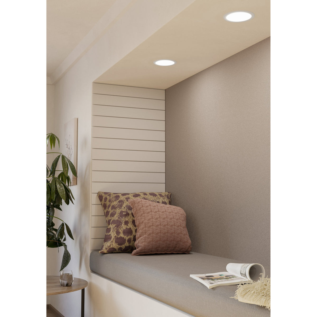 Gosmelle LED Downlight 11W IP44 in white, recessed into a ceiling above a window seat with cushions, lighting a neutral-toned reading nook.