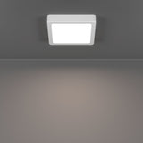 Gosmelle square LED downlight in white plastic, surface-mounted on a grey ceiling, showing its low-profile frame and illuminated diffuser panel.