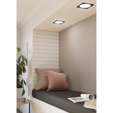 Gosmelle LED Downlight, square black-framed fixtures with white diffusers recessed into a sloped ceiling above a cushioned reading nook with pink and taupe cushions.