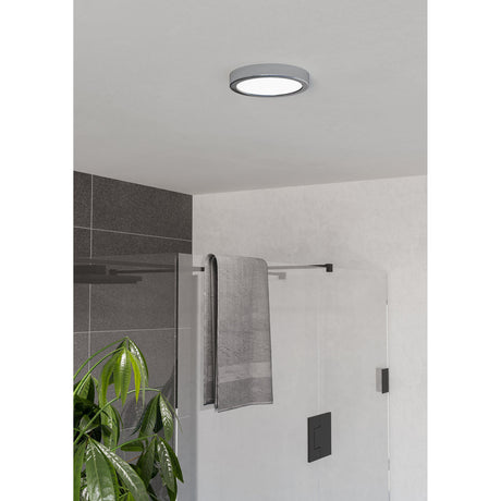 Gosmelle LED Downlight, a slim round chrome-finish fixture with white diffuser, shown fitted to a bathroom ceiling above a glass shower enclosure.