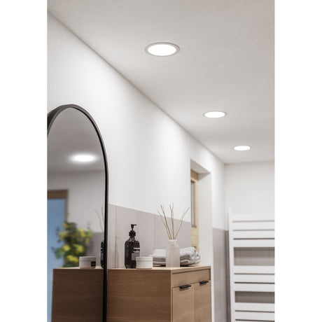 Gosmelle LED downlight in white plastic, 16.8cm round recessed fixture with flat diffuser, shown installed in a hallway and bathroom ceiling, IP44 rated.