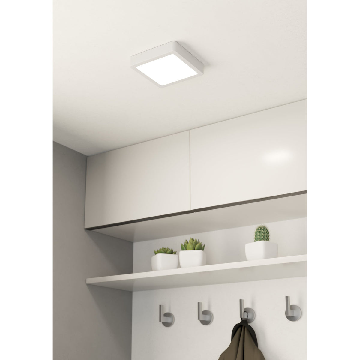 Gosmelle square LED downlight in white steel with a flush ceiling mount, shown above kitchen cabinets with a shelf, potted plants and coat hooks below.