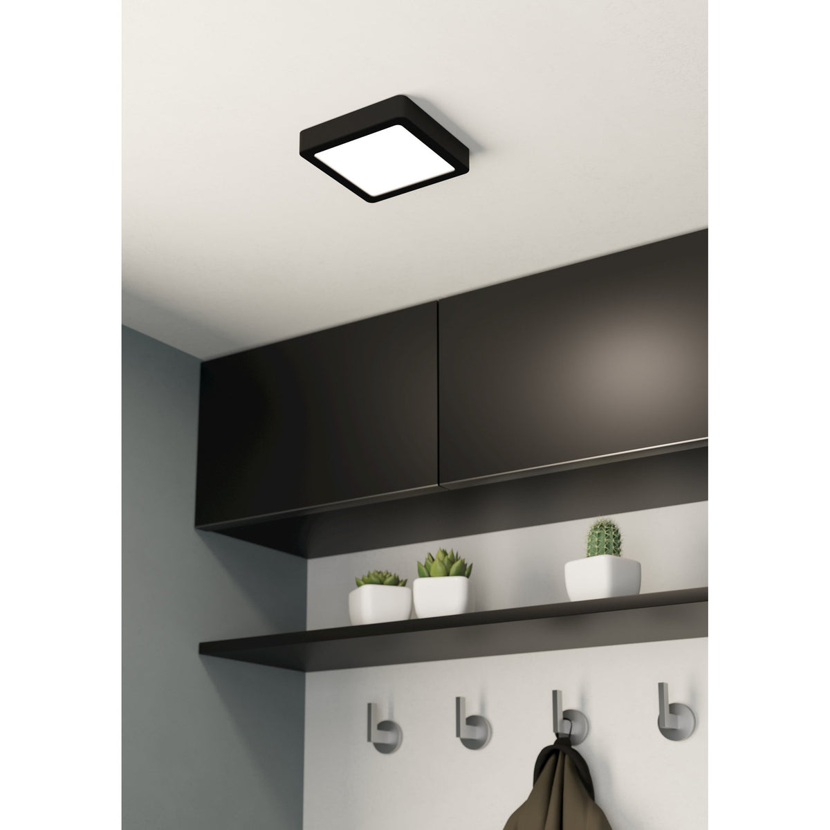 Gosmelle LED downlight in black steel with a square white diffuser, mounted on a white ceiling above dark cabinetry in a hallway setting.