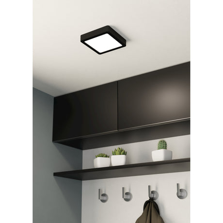 Gosmelle LED downlight in black steel with a square white diffuser, mounted on a white ceiling above dark cabinetry in a hallway setting.