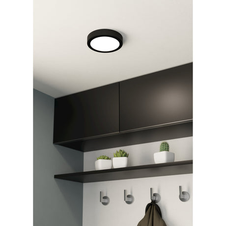 Gosmelle 16cm LED downlight with black steel body and round white shade, mounted flush on a white ceiling above dark kitchen cabinetry.