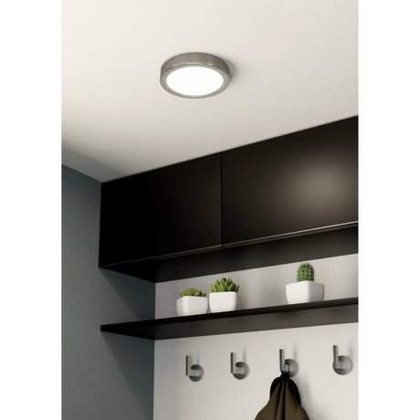 Gosmelle LED downlight in satin nickel, round low-profile ceiling fixture with white diffuser, shown above dark cabinetry in a kitchen hallway setting.