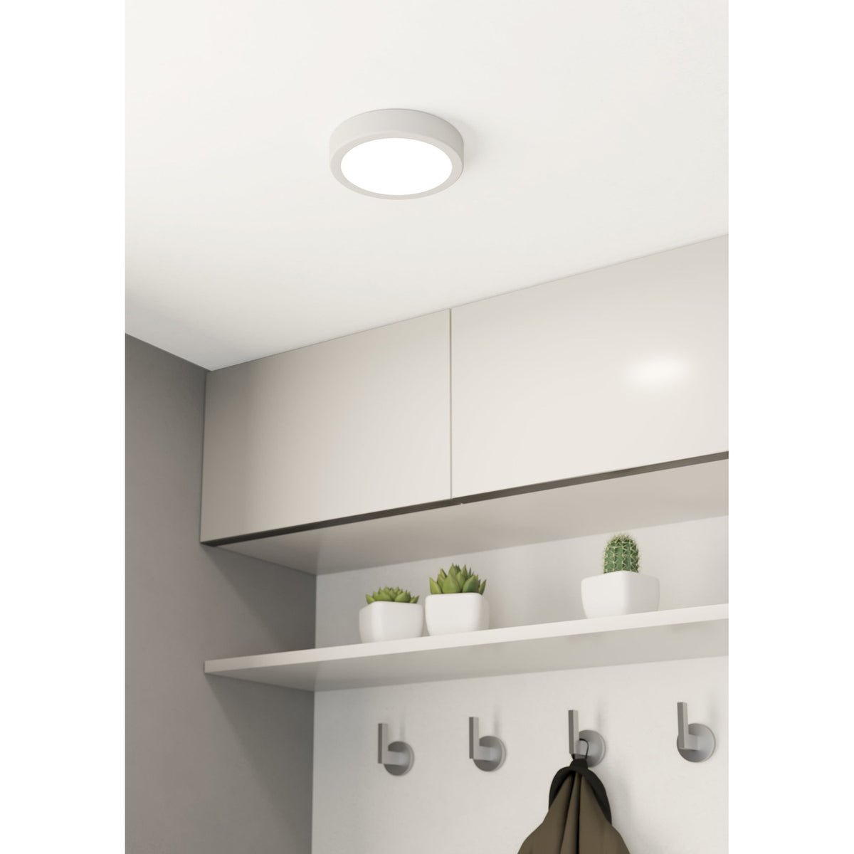 Gosmelle 16cm round LED downlight in white steel with a flush white plastic diffuser, fitted to a white ceiling above kitchen cabinetry with a shelf and hooks below.