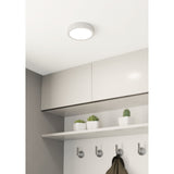 Gosmelle 16cm round LED downlight in white steel with a flush white plastic diffuser, fitted to a white ceiling above kitchen cabinetry with a shelf and hooks below.