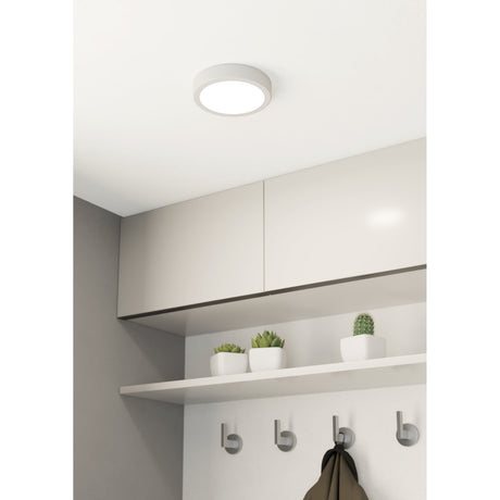 Gosmelle round LED downlight in white, 16cm, recessed into a hallway ceiling above fitted storage cupboards, emitting warm white light.