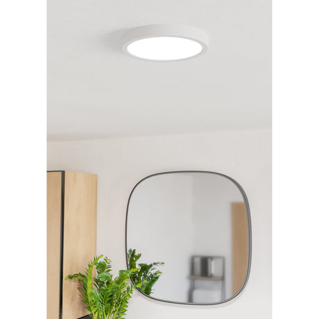 Gosmelle LED Downlight, a slim round white ceiling fixture with an opal diffuser, shown illuminating a hallway with a wall mirror and wooden furniture nearby.