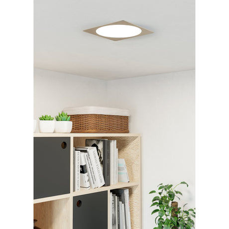 Gosmelle LED Downlight 21.6cm in satin nickel with square trim and round white diffuser, shown ceiling-mounted above a bookshelf in a living room.