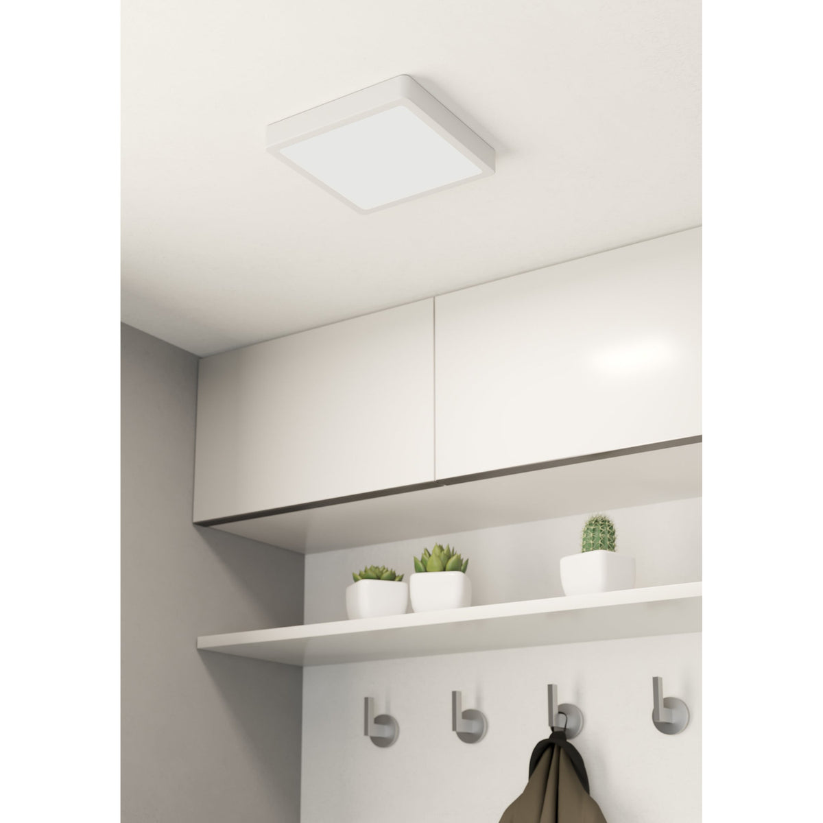 Gosmelle square LED downlight in white steel with flat plastic diffuser, mounted on a ceiling above white cabinetry in a kitchen setting.