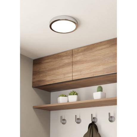Gosmelle LED Downlight 21cm in chrome with a white diffuser, mounted flush on a hallway ceiling above wood-panelled cabinets and a shelf with hooks.