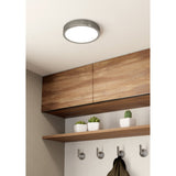 Gosmelle round LED ceiling downlight in satin nickel with white diffuser, shown on a hallway ceiling above wood cabinetry and an open shelf.