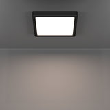 Gosmelle square LED downlight, 22 x 22cm matt black plastic frame with white diffuser, mounted on a grey ceiling, illuminated with warm light, IP44 rated.