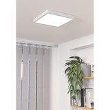 Gosmelle square LED downlight in white steel with a flush plastic diffuser, mounted on a ceiling near vertical blinds, a shelf with plants and books.