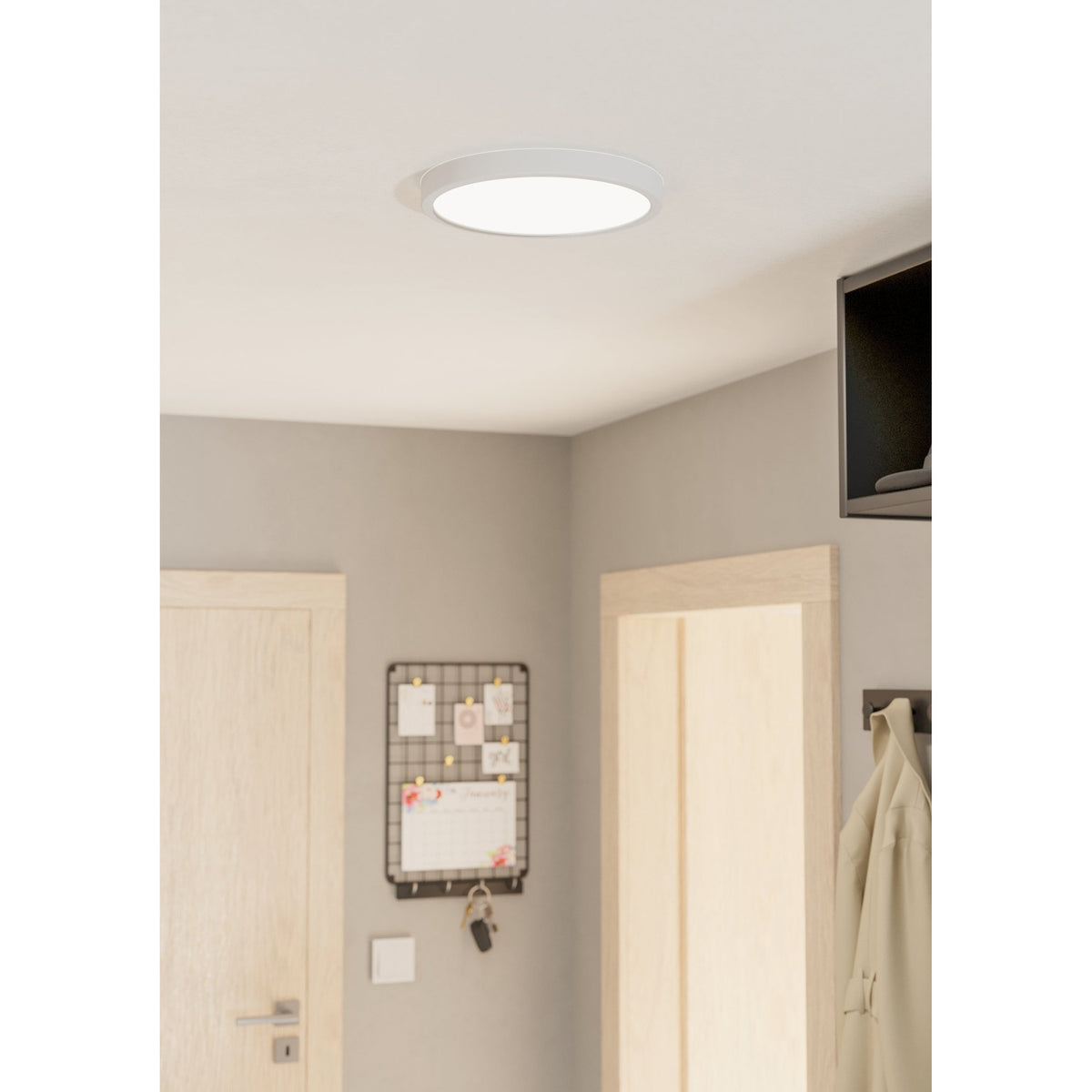 Gosmelle round LED downlight in white steel with a wide diffuser, fitted flush to a hallway ceiling near a door, pinboard, and wall-mounted TV.