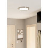 Gosmelle round LED downlight in satin nickel with white diffuser, fitted flush to a hallway ceiling near wooden doors and a pinboard.