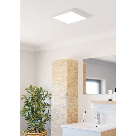Gosmelle square LED downlight in white, 29 x 29cm ceiling-mounted plastic panel, shown fitted above a bathroom vanity with wood-panelled storage and mirror.