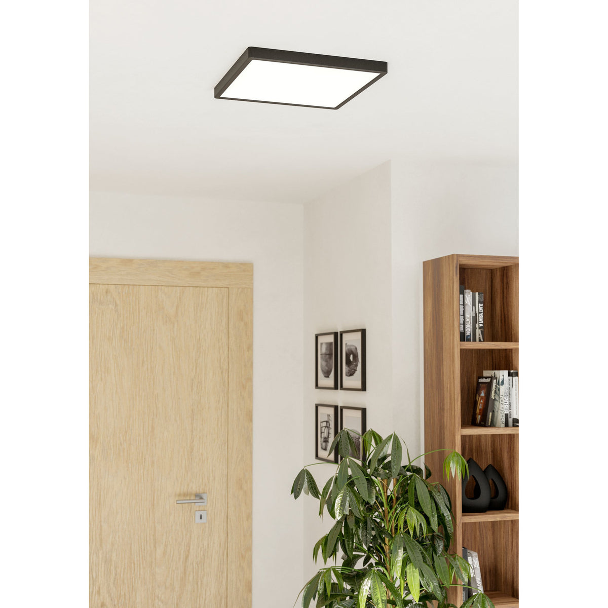 Gosmelle LED Downlight 39 x 39cm in black, a slim square ceiling panel with white diffuser, shown mounted in a hallway near a wooden door and bookshelf.