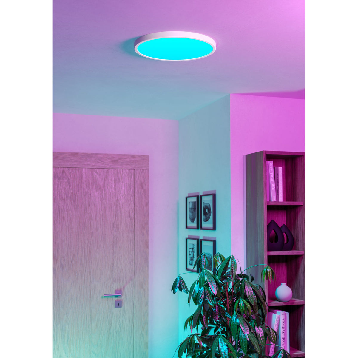 Gosmelle 38.9cm round LED downlight in white, shown recessed in a ceiling glowing cyan-blue, illuminating a hallway with a wooden door and pink-lit shelving.