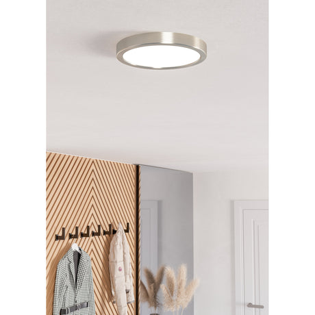 Gosmelle Smart LED Downlight, a slim round ceiling fixture with satin nickel rim and white diffuser, shown illuminated in a hallway near a coat rack and mirror.