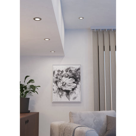 Gosmelle Smart LED Downlights in satin nickel recessed into a living room ceiling, illuminating a white wall with framed floral art, plant, and sideboard below.