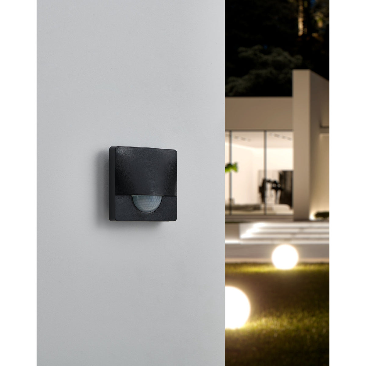 Granvena Motion Sensor in black, square plastic housing with rounded corners and white half-dome lens, mounted on a light grey wall near a modern house exterior at night.