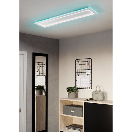 Grolane rectangular LED ceiling panel light in white steel and plastic, mounted on a hallway ceiling with a cyan RGB glow around its edge above a wood console table.