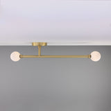 Gunning Twin Glass Globe Semi Flush Ceiling Light IP44 in satin brass, with two opal glass globes on a slim horizontal bar, mounted close to a white ceiling.