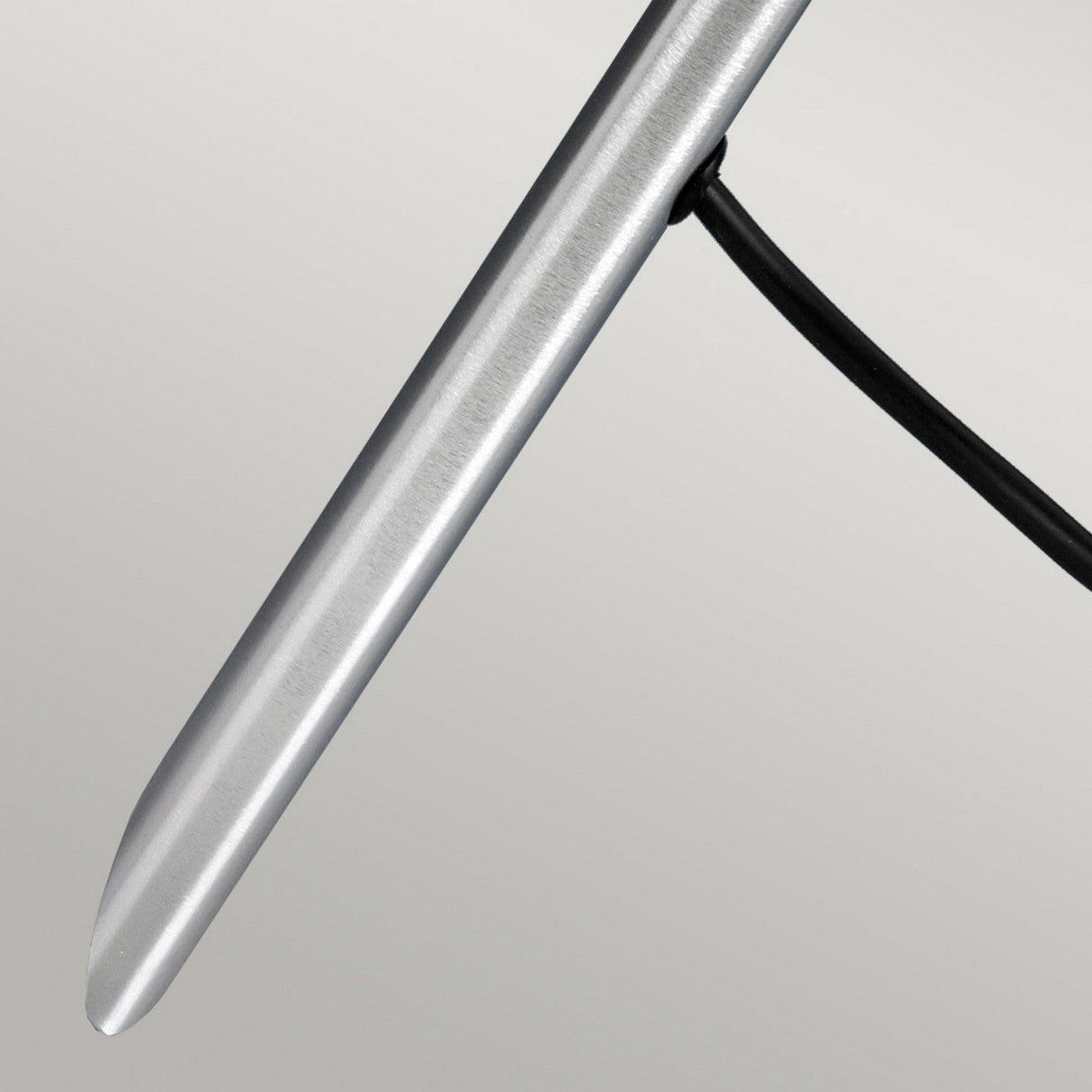 A close-up of the Spennymoor 1 x 12V Spotlight and Pole, featuring a sleek, metallic design reminiscent of a pen with its smooth cylindrical form and an attached thin black wire, set against a plain background.