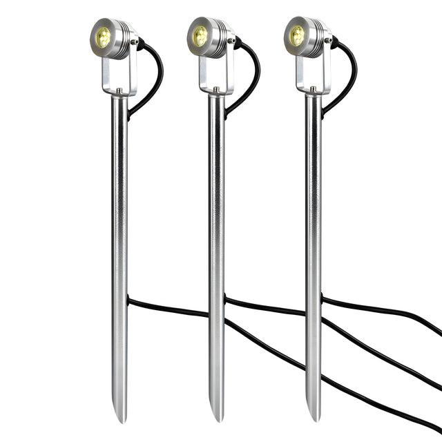 The Spennymoor Kit features three 12V spotlights with sleek, metallic designs and round LED heads, providing elegant illumination for gardens. Each spotlight is connected by a visible 6-meter black cable, exuding a minimalist and modern aesthetic ideal for outdoor lighting. The set includes three poles and a 12V transformer to stand the lights upright in a neat row.