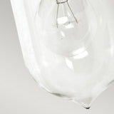 Close-up of a clear glass light bulb positioned at a diagonal angle against a plain white background, evoking the elegant design of the Sandown 1 Light Outdoor Wall Lantern - Black. The internal filament and structure of the bulb are clearly visible, capturing a classic aesthetic reminiscent of cast aluminum fixtures.