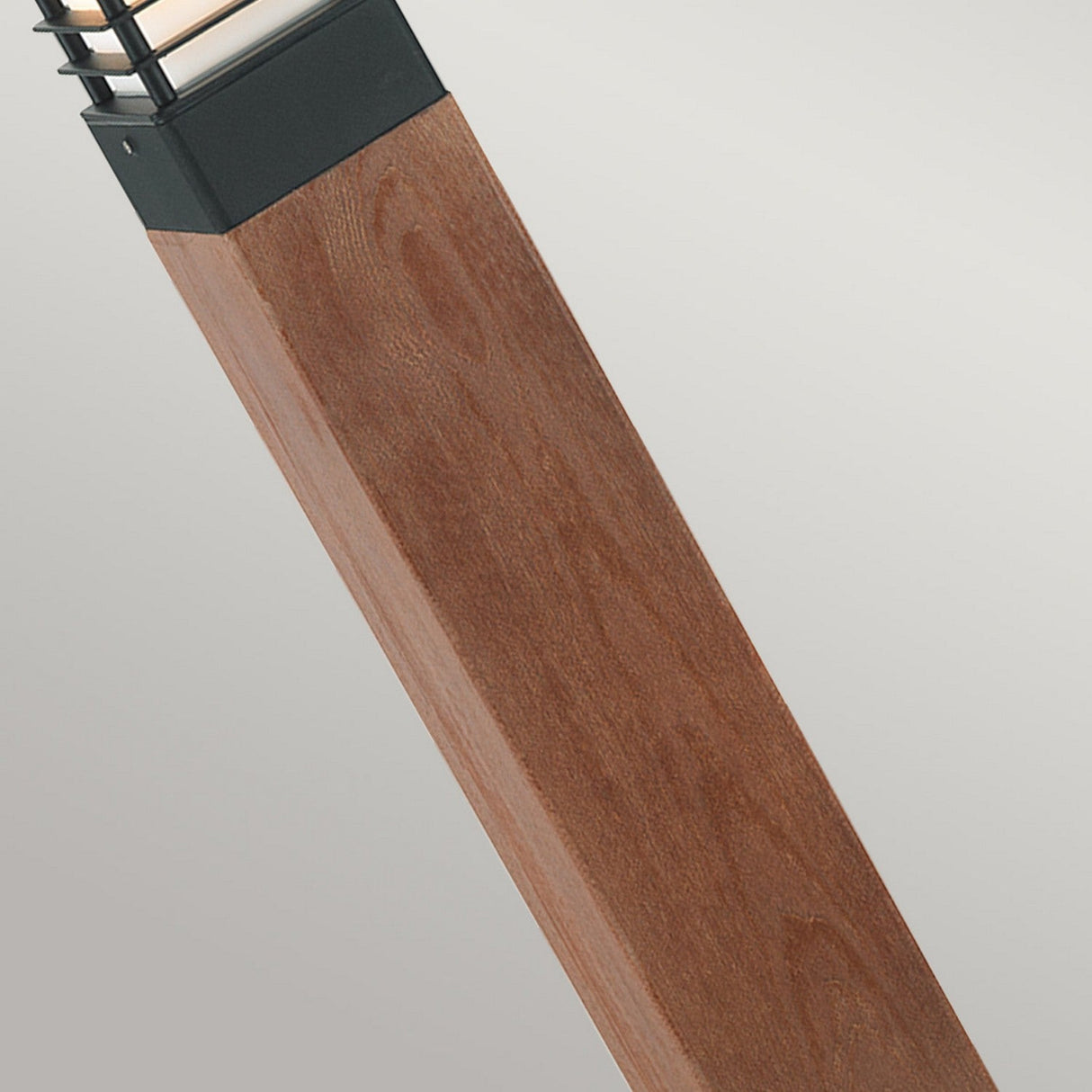 Close-up of the contemporary Halmstad 1 Light Large Wooden Bollard - Black, featuring a wooden texture and metal top, enhanced by its IP65 rating for durability. The bollard showcases a clean, minimalist design set against a neutral background.