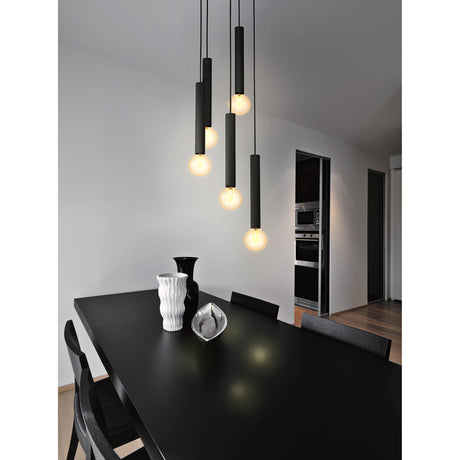 Halmarne 5 Light Pendant in black steel with slim cylindrical shades at staggered heights, shown over a black dining table with exposed bulbs lit.
