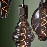 Halo Cable Cord Set E27 in gunmetal, a knurled cylindrical E27 lampholder on black fabric flex, shown fitted to a decorative glass pendant bulb with spiral LED filament.