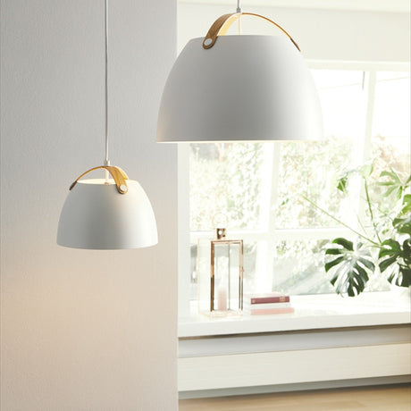 Oslo Pendant Light 24cm in white with an arched oak strap handle, shown in two sizes hanging in a bright living space near a window.