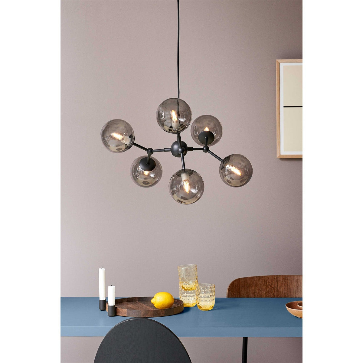 Atom Large 6 Light Smoke Glass Chandelier in black, six smoked glass spheres branching from a central hub, shown suspended above a dining table.