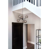 Atom Large 6 Light Smoke Glass Chandelier in black, with smoked glass spheres branching from a central hub, hung in a hallway beneath a staircase.