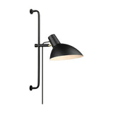Metropole Grande Wall Light in black, a wide angled dome shade with pale interior on a short arm and brass collar, mounted on a long black wall rail, shown on a plain white background.